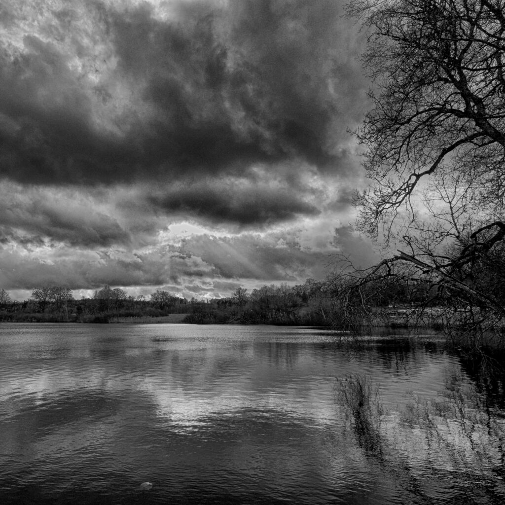 Dramatischer Himmel über dem See in schwarz-weiß