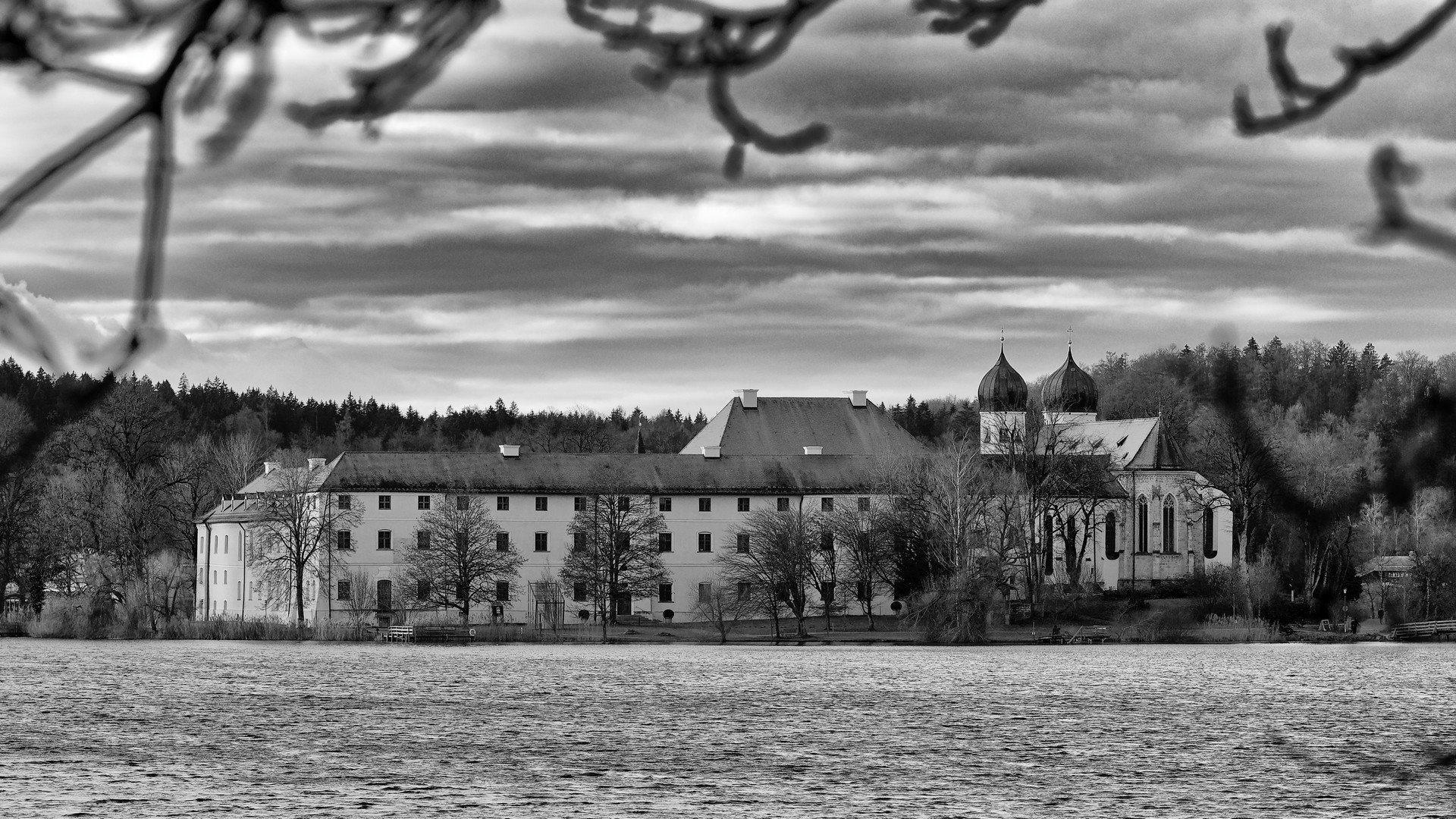 Bild auf den Klosterbau mit der Klosterkirche mit Türmen über den See in schwarz-weiß.